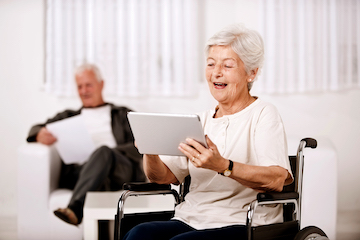 Senior woman in a wheelchair using a tablet computer
